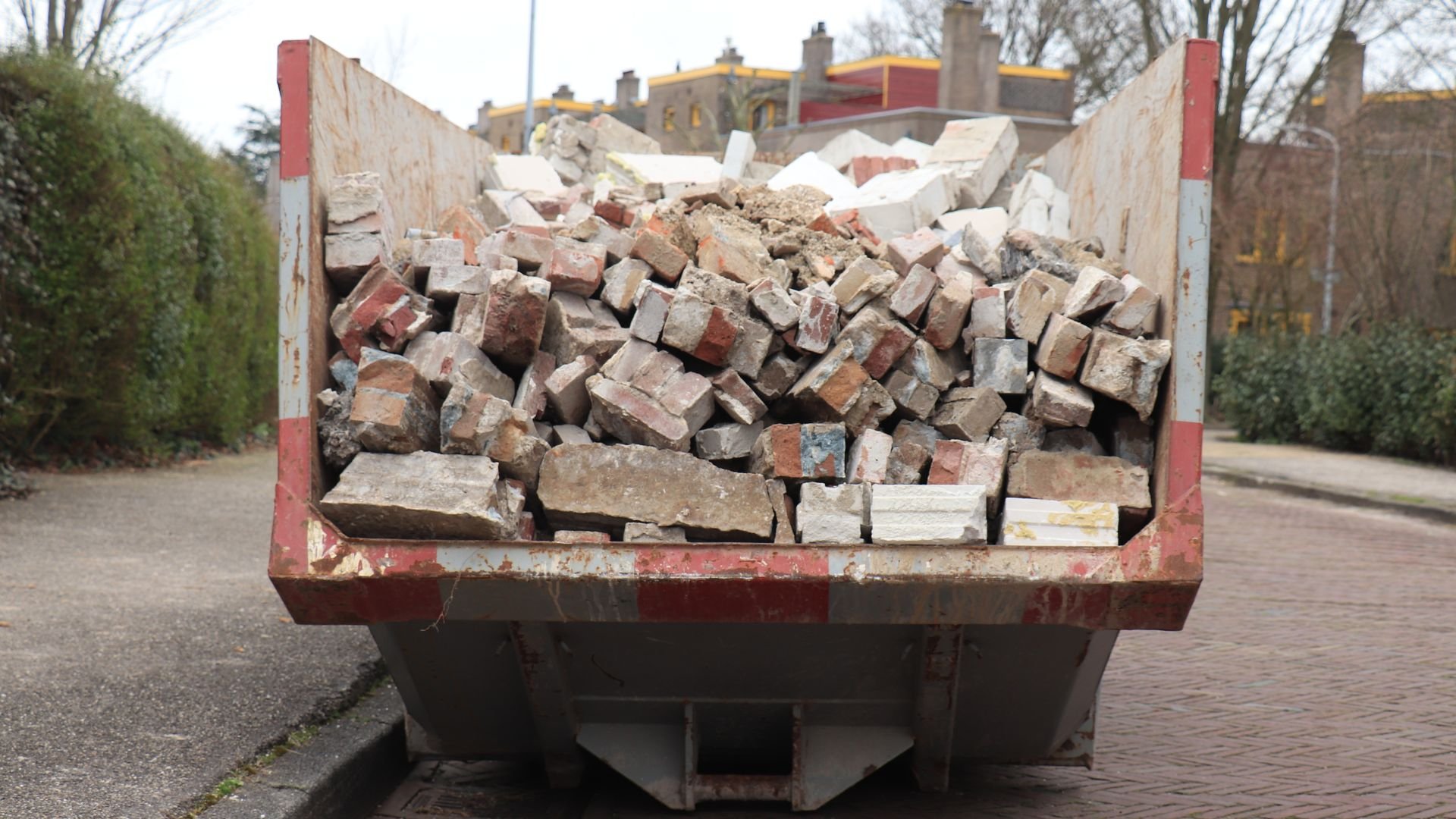 Dumpster filled with broken bricks and construction debris